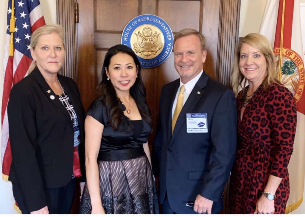 Group of insurance professionals posing in front of the House of Representatives seal, advocating for legislative issues at the Independent Insurance Agents and Brokers of America Conference in Washington, D.C.